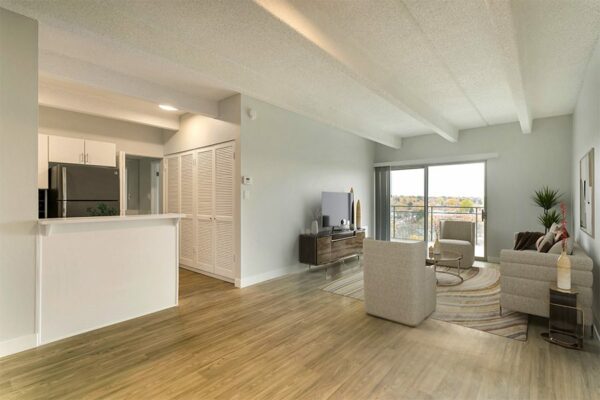 Living room with wood floor, modern furniture, and large balcony door.