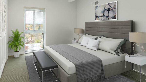 Bedroom with plush bed, bedside tables with lamps, and large window.