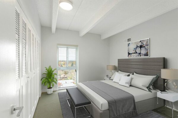 Bedroom with plush bed, bedside tables with lamps, and large window.