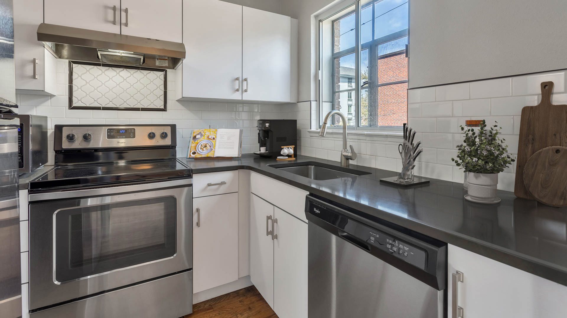 Kitchen with white cabinets, gray counters, and stainless steel appliances.