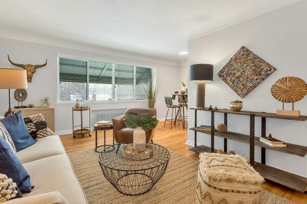 Living room with clean decor, window, view into the kitchen area