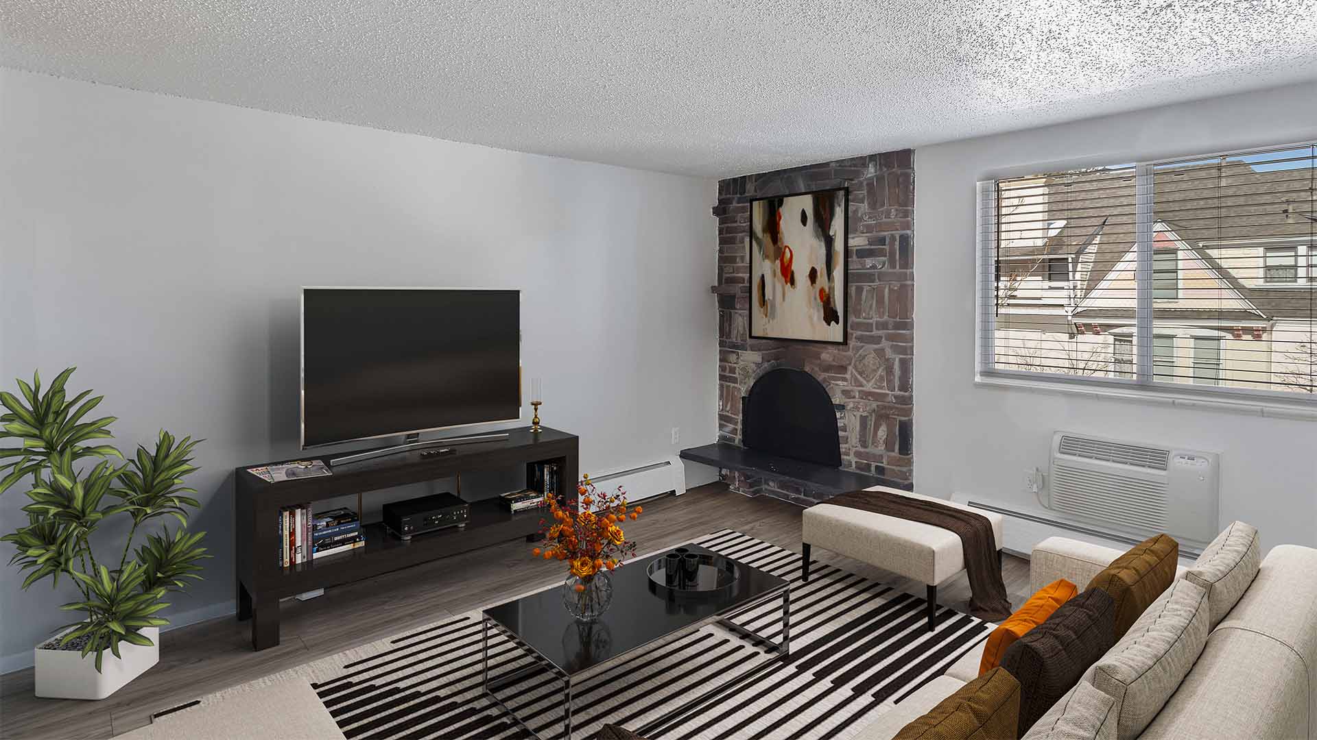 Apartment living room with modern furniture, large TV, and fireplace.