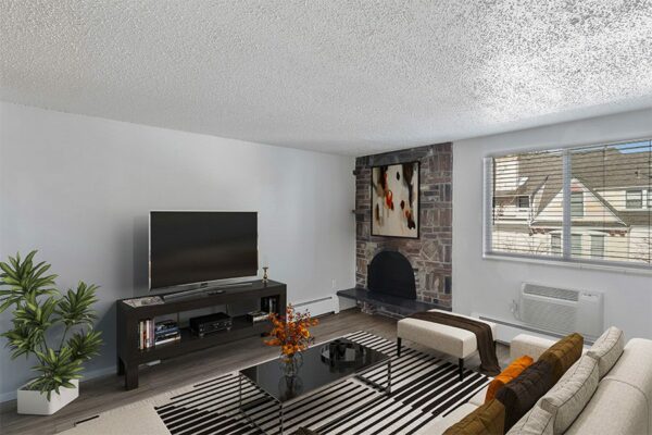 Apartment living room with modern furniture, large TV, and fireplace.