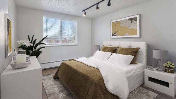 Apartment bedroom with plush bed, framed art, and large window.