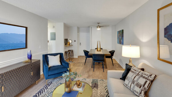 Living room with wood floor, large rug, plush seating, eclectic furniture, and modern dining table.