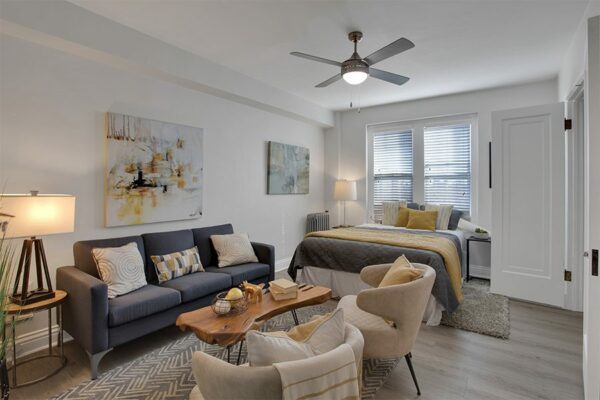 Studio living area with plush seating, large bed, and artwork.