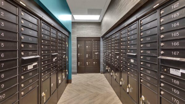 Mail room with tiled floor, blue accent wall, mailboxes, and package lockers.