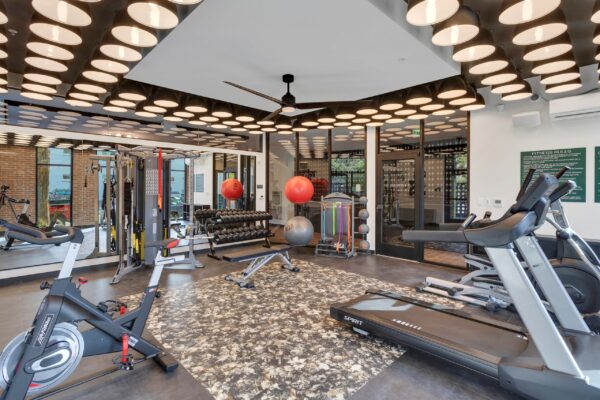fitness center with designer lighting in ceiling, dumbbells, bikes, cables, and bands