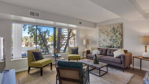 Rendering of a living room with wood floors, white walls, and a large window.