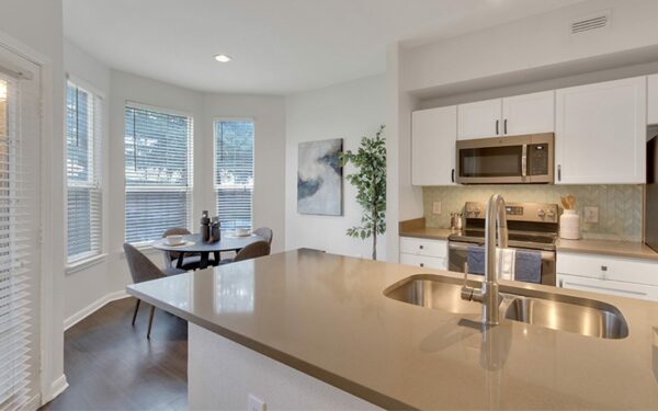Apartment kitchen with island and dining area.