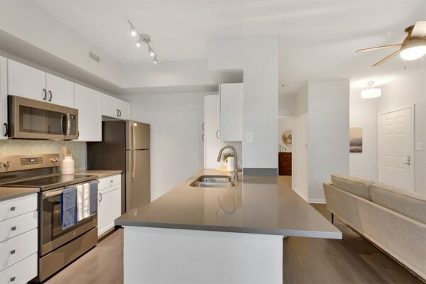 Kitchen with island, sink and refrigerator.