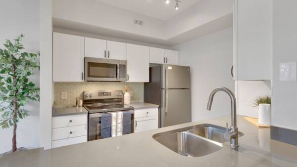 Kitchen with white cabinets, gray countertops, and stainless steel appliances.