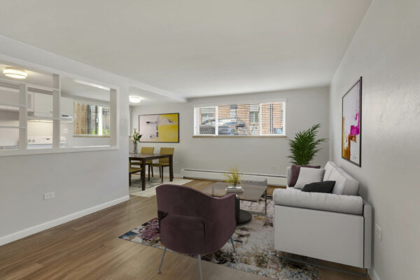 Apartment living room with plush furniture and framed artwork.