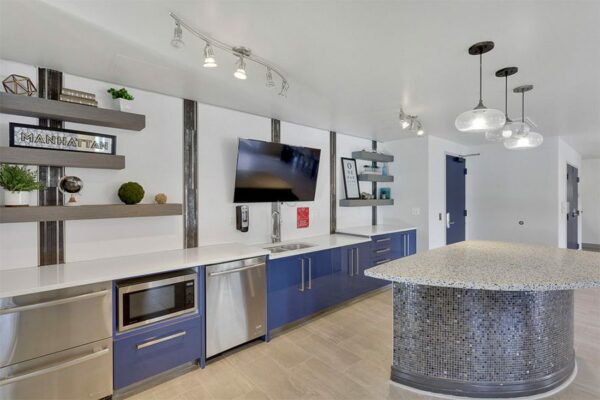 Clubhouse at 515 Clarkson with a kitchen area with a large island, dishwasher, and television.