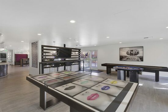 Lounge with games tables, wall mounted TV, and framed artwork.