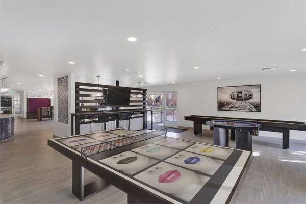Lounge with games tables, wall mounted TV, and framed artwork.
