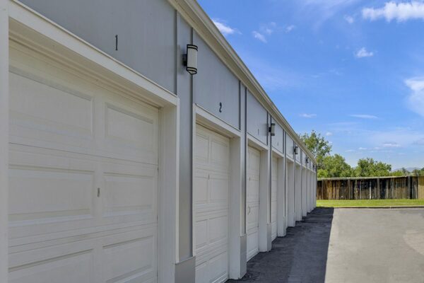 Numbered garages with outdoor lights and grassy area.