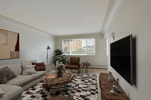 one bedroom apartment living room with couch, coffee table, tv, and large window