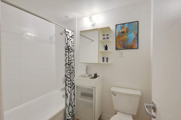 bathroom with white cabinets and small sink