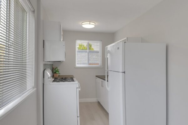 kitchen with white counters and cabinets and fridge with stainless steel appliances