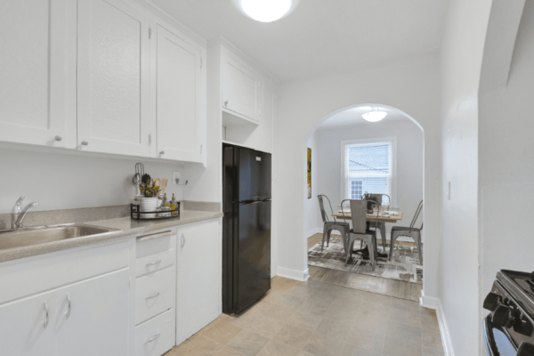 kitchen with refrigerator, sink, and stove with view to dining area