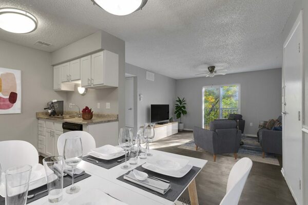 Apartment living area with modern kitchen, plush living room, and balcony door.
