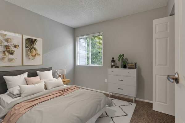 Bedroom with plush bed, bedside tables with lamps, and framed artwork.