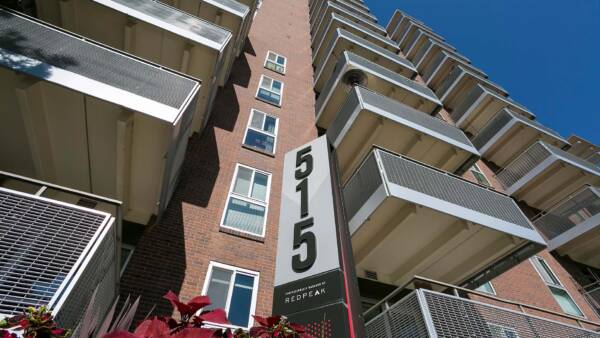 515 Clarkson apartments with brick construction, large balconies, and monument sign.