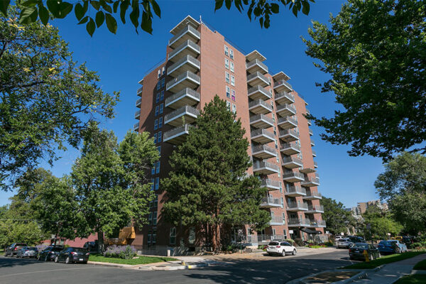 515 Clarkson apartment exterior with large balconies and lush trees.