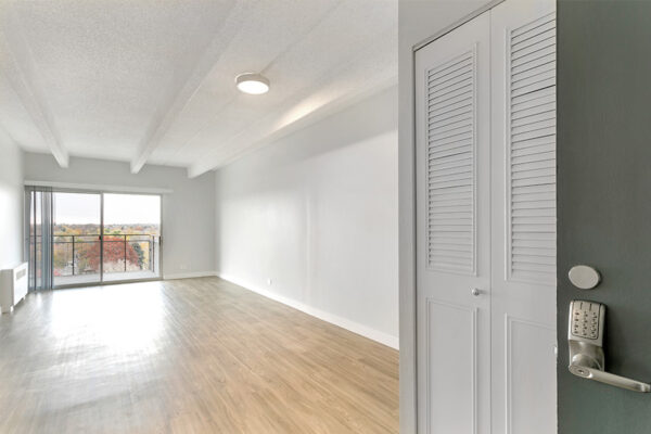 Living room with wood floor, cool gray walls, and sliding door to balcony.