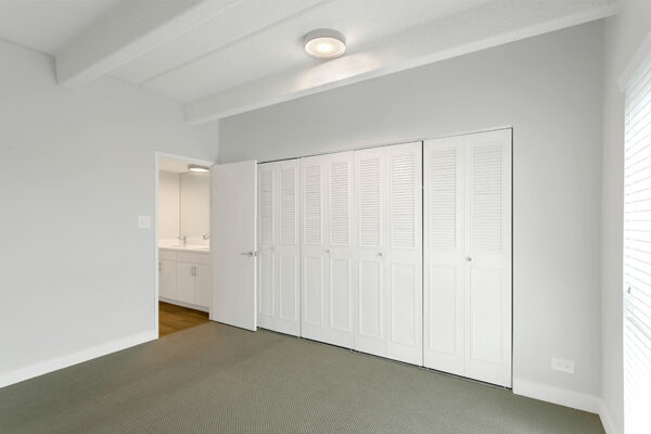 Bedroom with carpet, cool gray walls, and large closet.