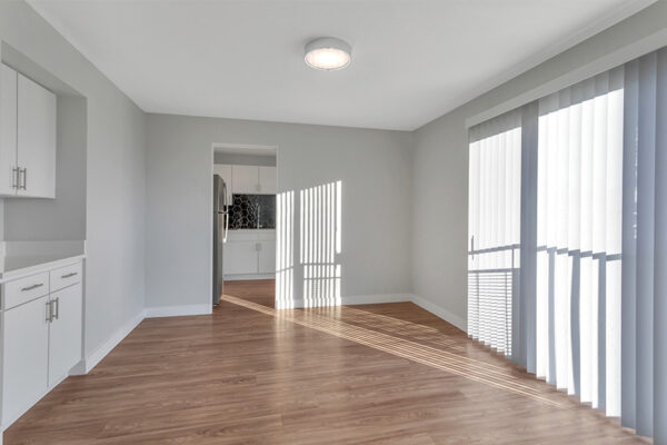Living room with wood floor, cool gray walls, and sliding door to balcony.