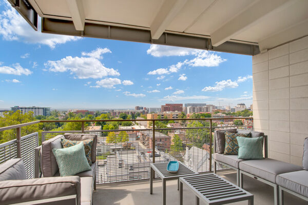 Balcony with metal railing and outdoor furniture overlooking Denver.