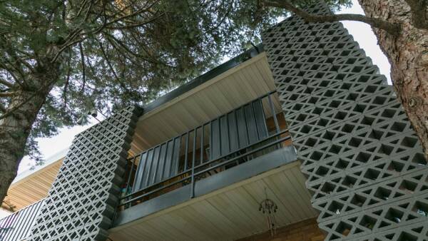 70 Clarkson apartment balconies with decorative cinderblock construction and large trees.