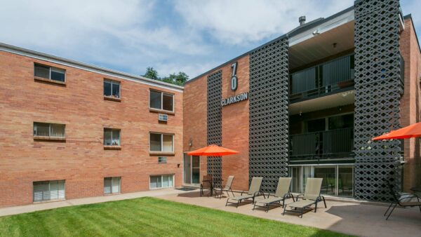 70 Clarkson courtyard with grassy lawn and outdoor furniture overlooked by apartment balconies.