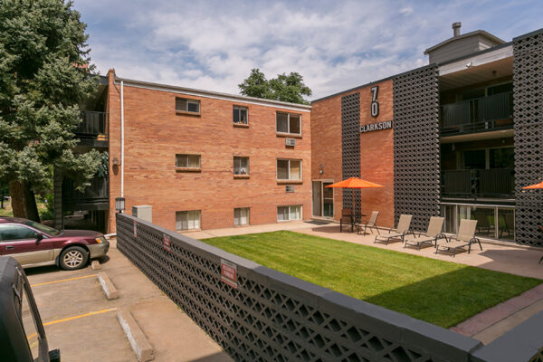 70 Clarkson apartment courtyard with lounge chairs and lawn overlooked by apartment balconies.