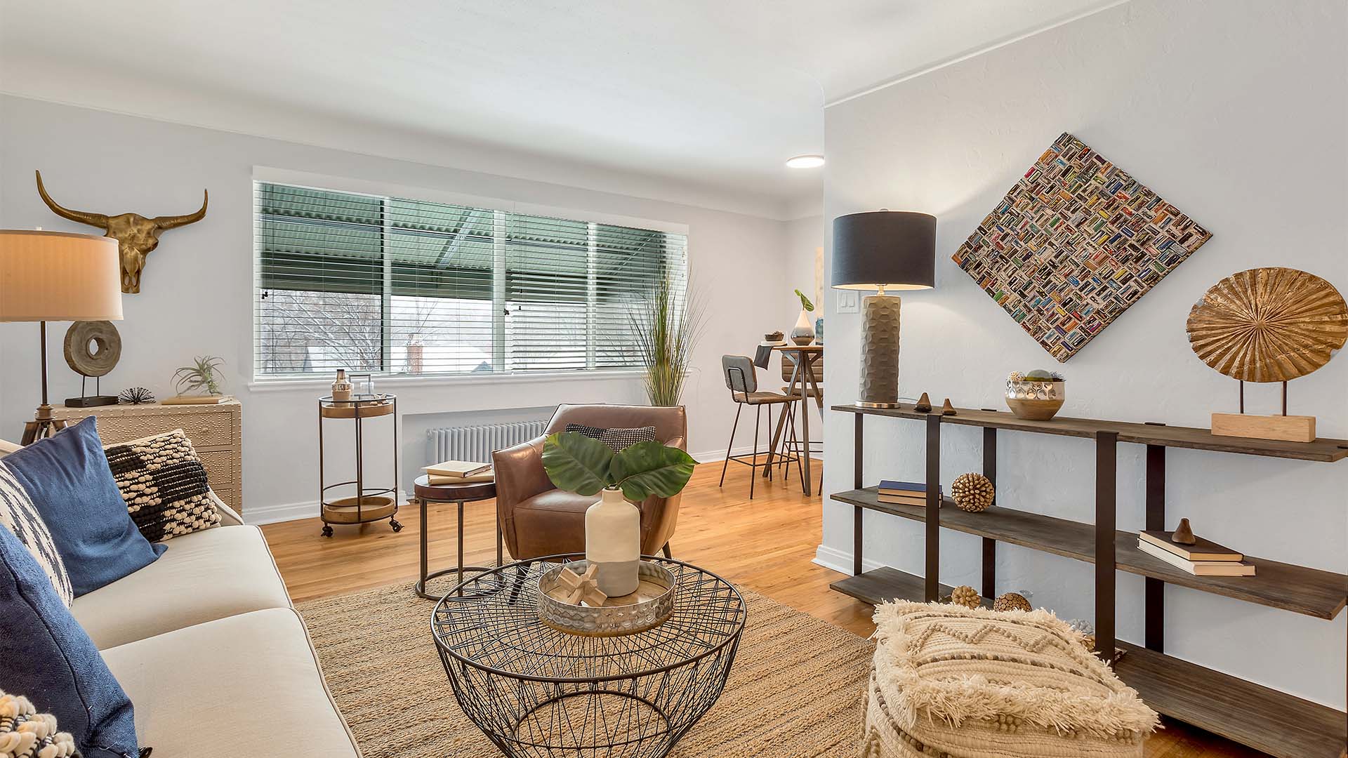 Living room with eclectic decor, plush seating, modern furniture, and large window.