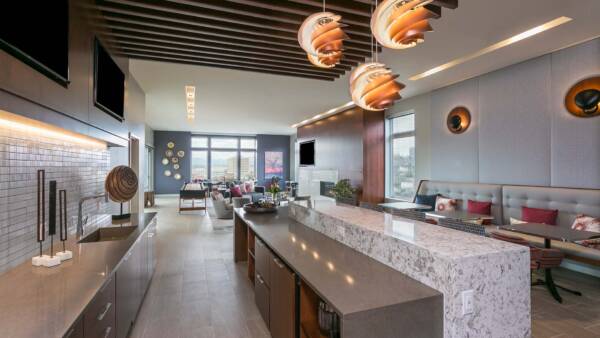 Lounge with comfortable seating, games area, community kitchen, and modern furniture and artwork.