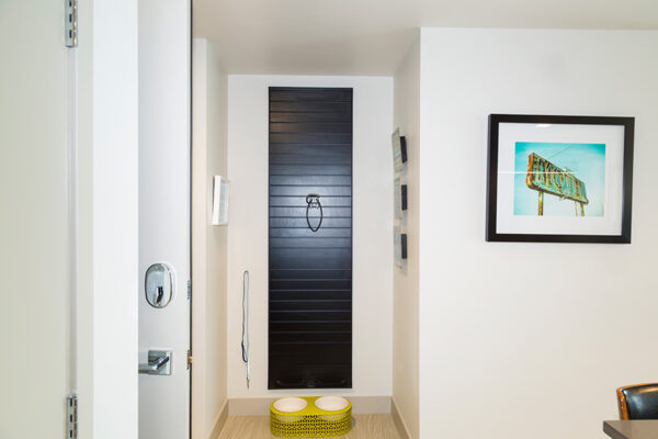 Apartment hallway with storage and dog bowls.