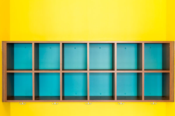 Detail of blue storage cubes on bright yellow wall.