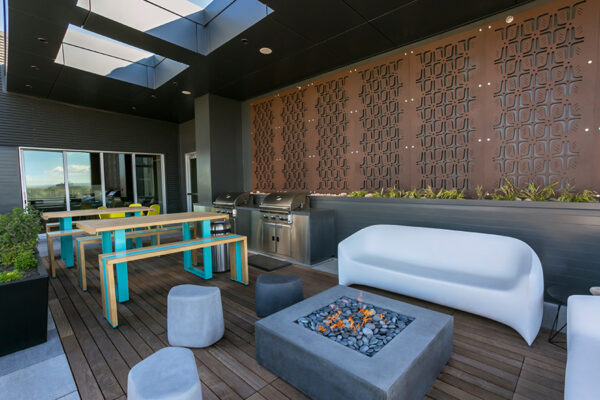 Outdoor patio with molded furniture, fire pit, bar picnic tables, and built in BBQ grills.