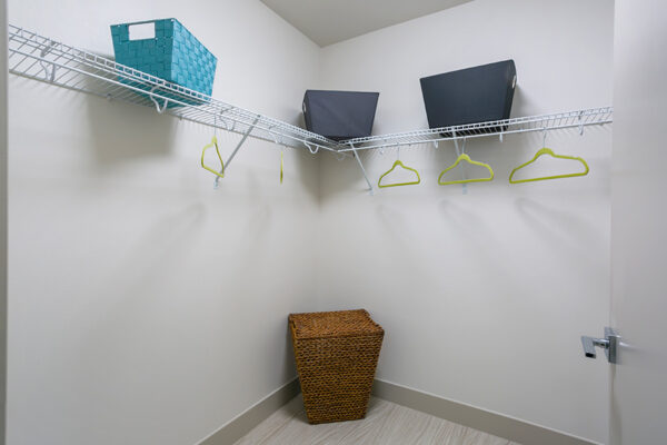 Walk in closet with wood floor, wire shelving, and wicker laundry basket.
