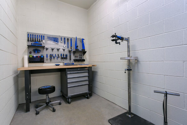 Bike repair room with bike stand and work bench with tools.