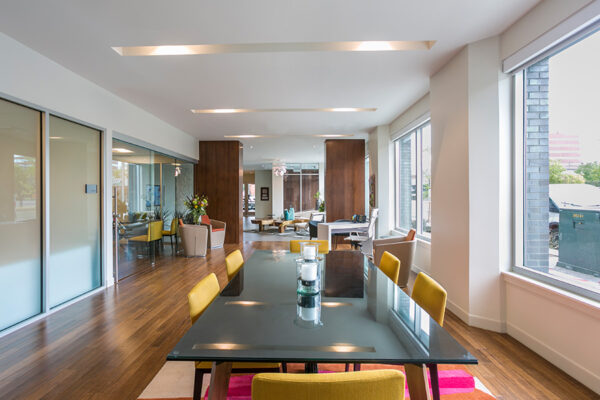 Lounge with large dining table and lounge chairs with natural light.