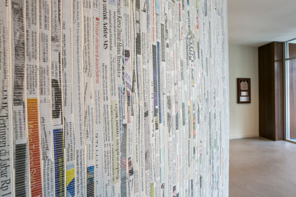 Detail of wall decorated with text on paper.