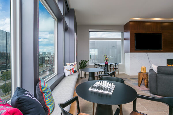 Lounge with bench seats in front of large windows with chess table and wall mounted TV.
