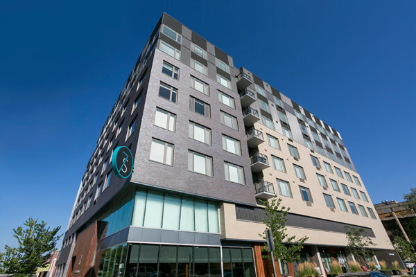 Exterior of 7 S Denver Haus apartments showing modern architecture and brick construction.
