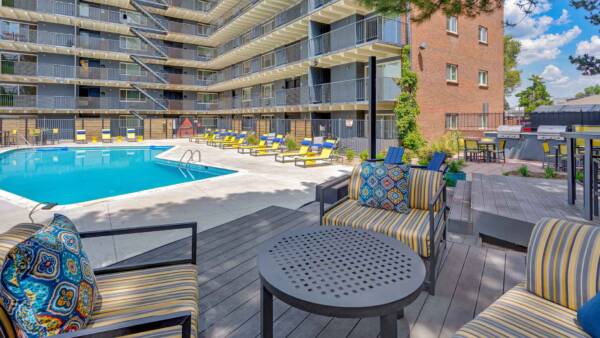 Pool area with built in BBQ grills, plush outdoor seating, and pool.