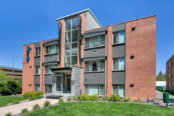 870 Cherry apartments with brick construction, modern updates, and grassy lawn.