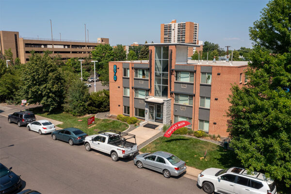Aerial view of 870 Cherry building with brick construction, grassy lawn, and street parking.